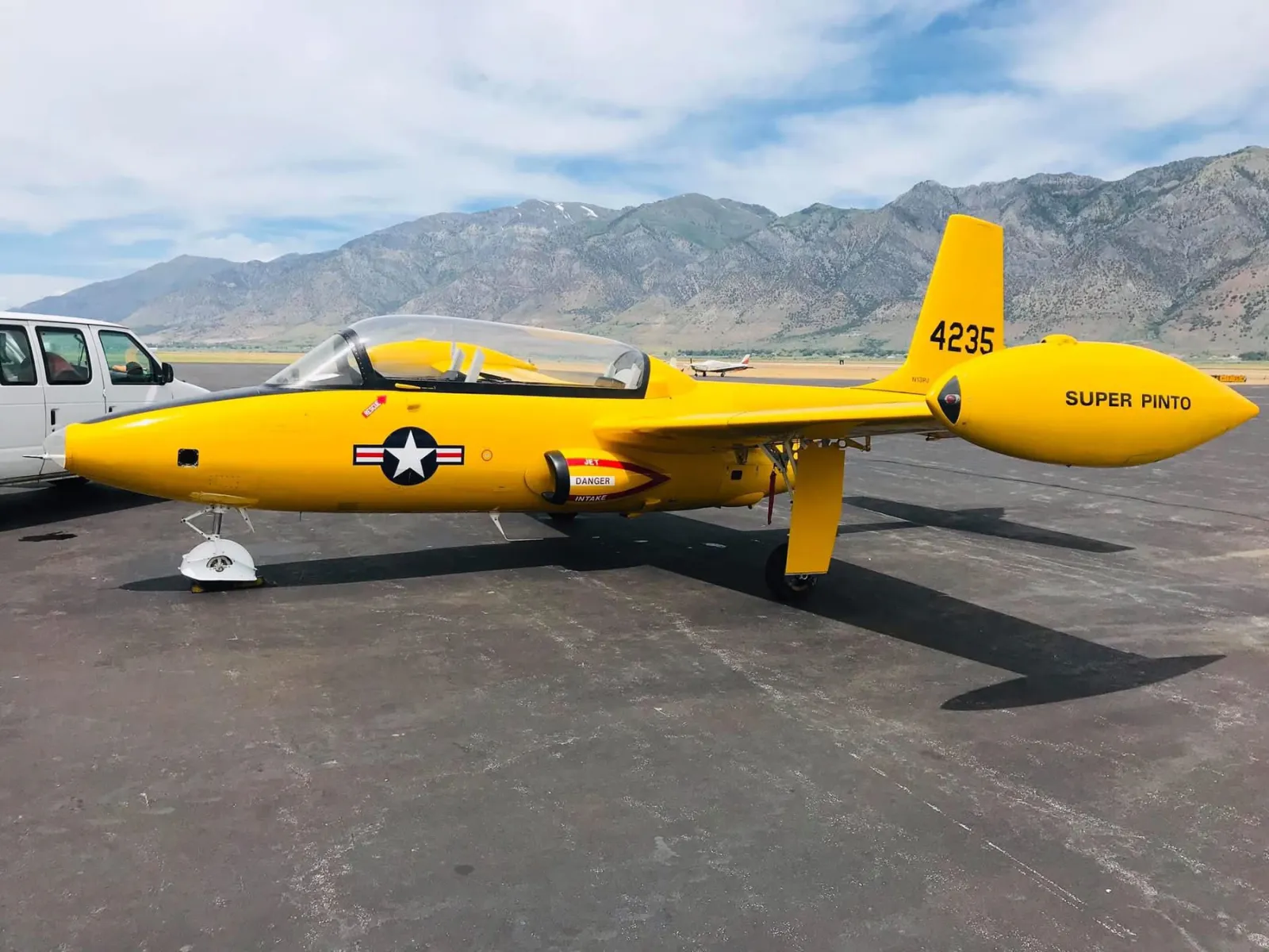 Yellow Super Pinto military jet on tarmac